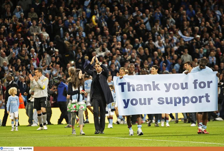 Maggio 2011: Roberto Mancini, amatissimo dai tifosi, sfila a fianco dello striscione di ringraziamento del pubblico di Manchester (Action Images) 